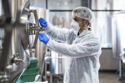 worker cleaning production equipment