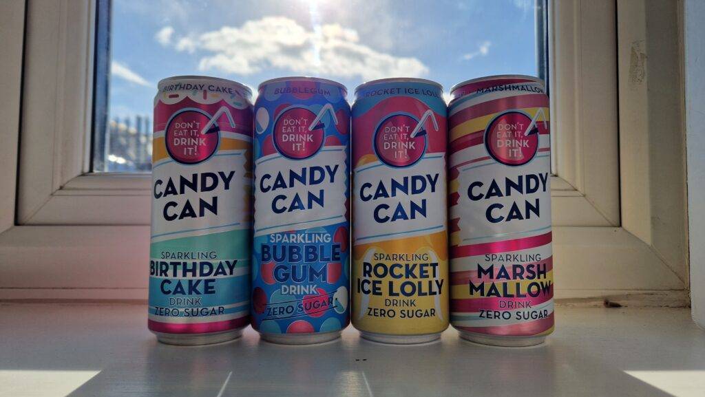 four soda cans on a window sill