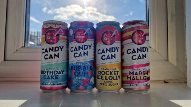 four soda cans on a window sill